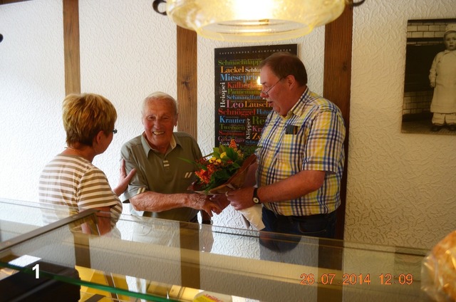 Eheleute Leni und Bernward Hennes überraschen den ältesten und treuesten Kunden, Heinz Steinhanses mit einem Blumenstrauß, um ihm und seiner Frau Anita den Abschied vom Geschäft Leopolds zu erleichtern.